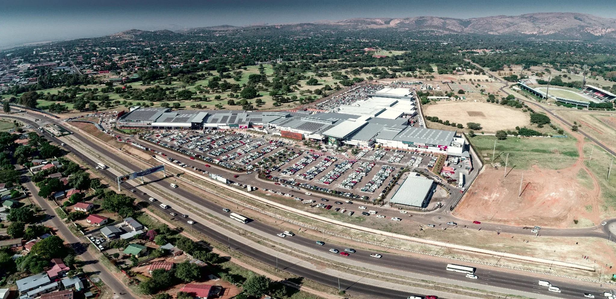 Rustenburg Mall from the air alongside the highway, with the hills of the Magaliesberg behind