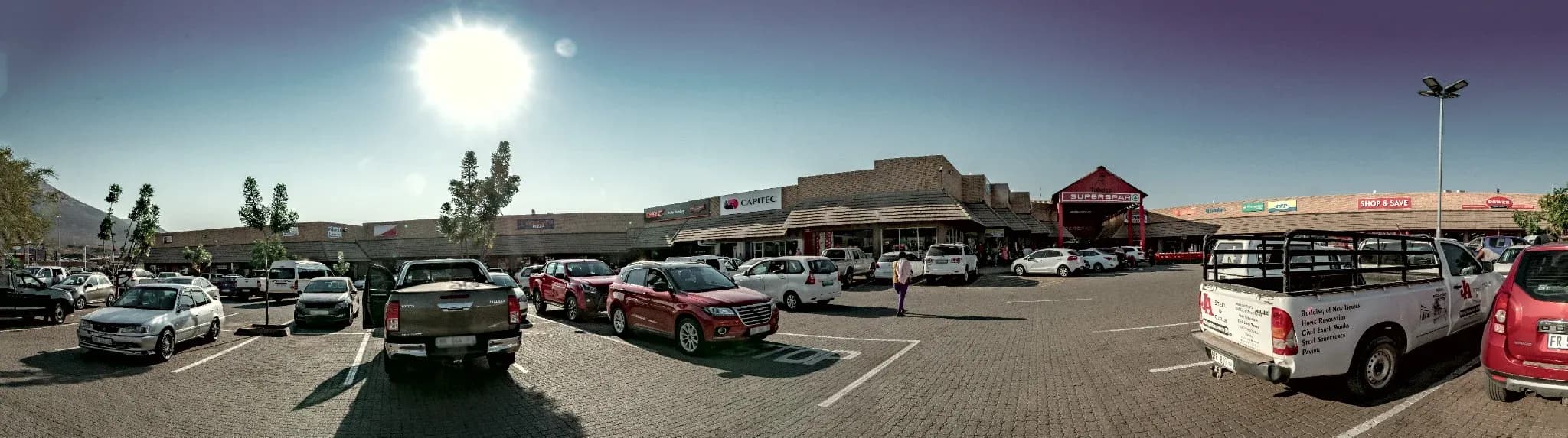 Shoppers and parked cars in front of the Twin City Burgersfort shopfronts
